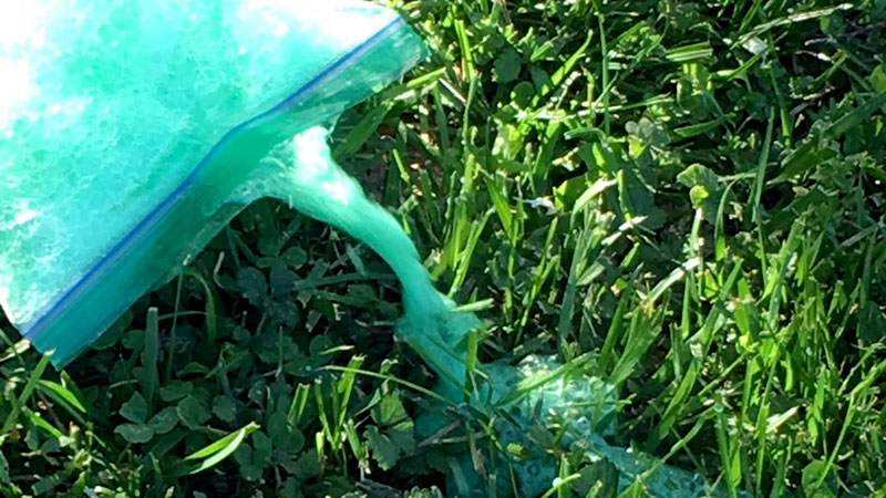 Ziploc bag laying in the grass exploding with a chemical reaction.