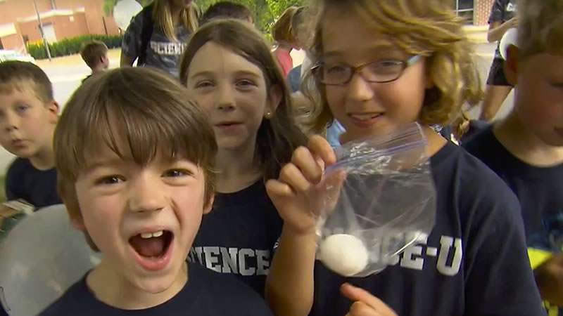 Excited kids show off an egg that they will try to protect with their egg lander design.