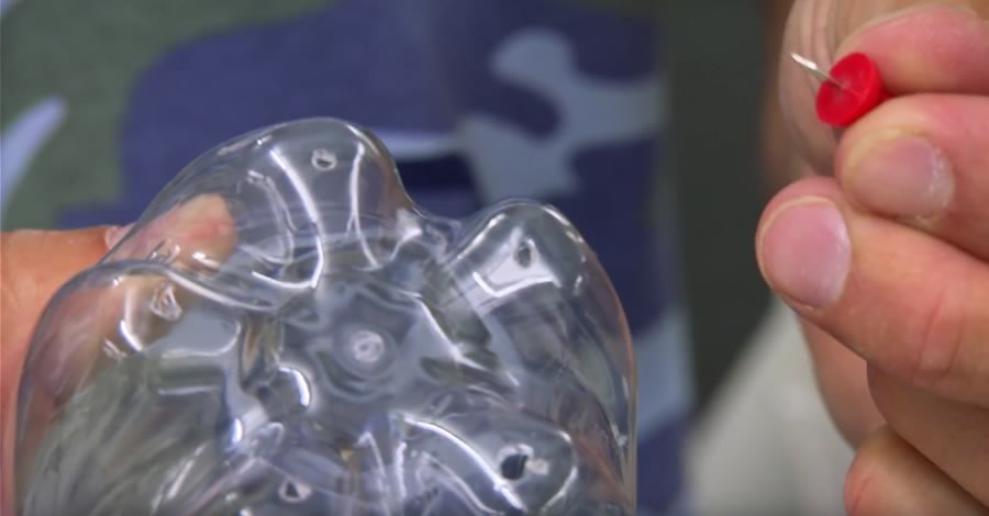 Close up of holes punched into the bumps of a 1-liter soda bottle base.